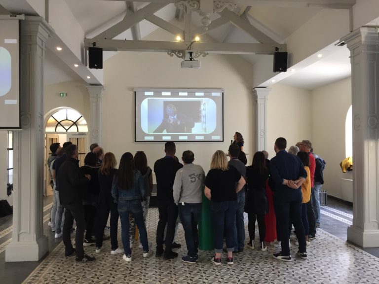 Aperçu d'une intervenante présentant auprès de collaborateur.rice.s notre animation ludique ciné quiz