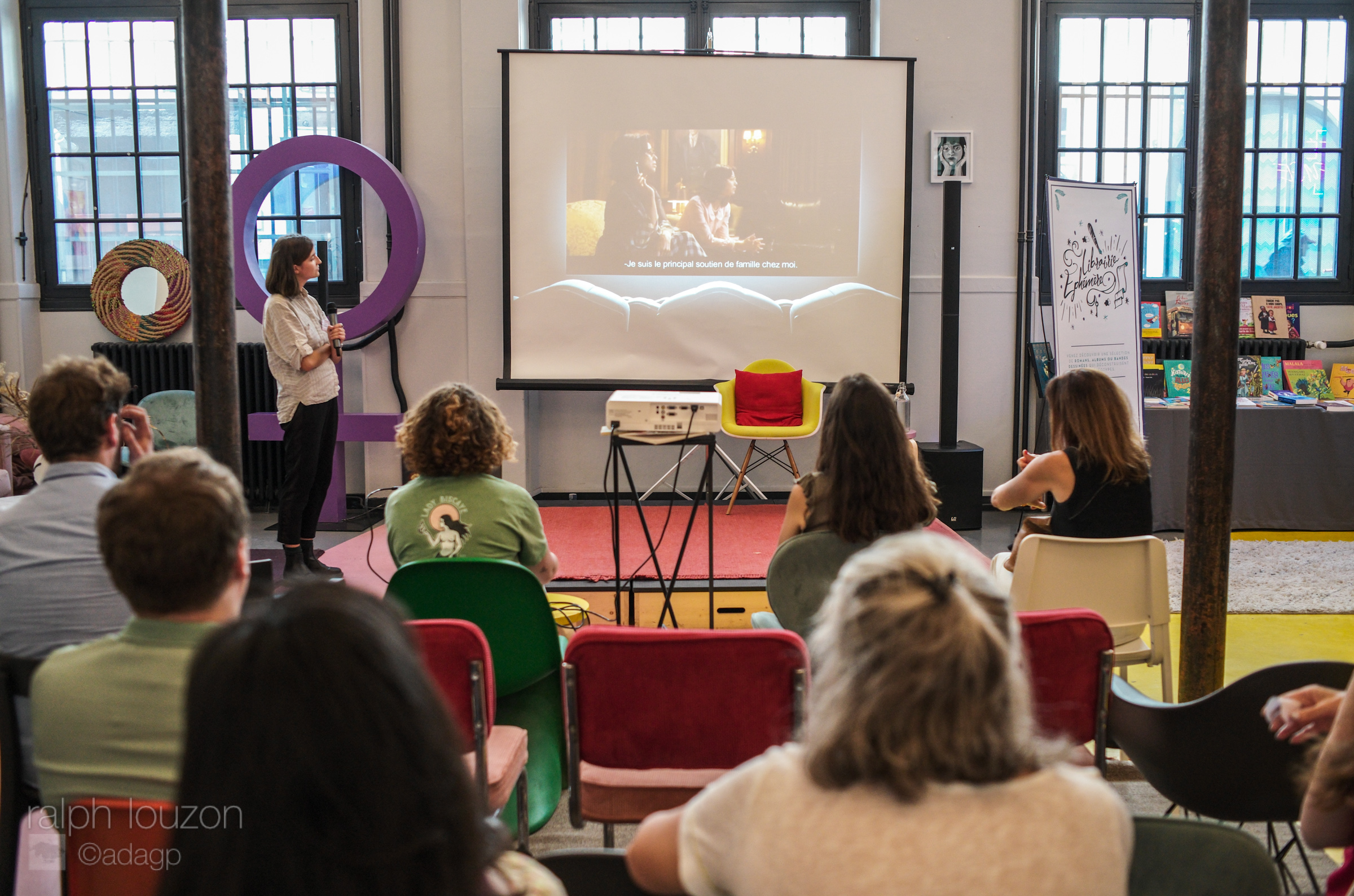 Camille Dubourdieu anime le Ciné Quiz spécial Violences Sexistes et Sexuelles, un groupe de personnes est assis sur des chaises devant elle.