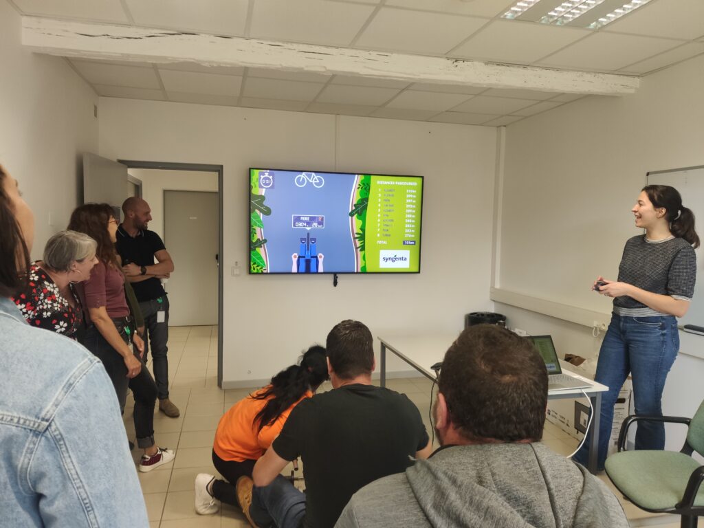 Handisport : aperçu de plusieurs collaborateur.rices en train de regarder un collaborateur en train d'effectuer le challenge connecté handbike