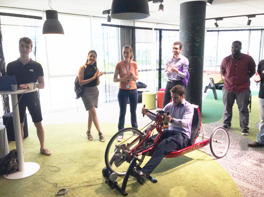 Handisport : aperçu de plusieurs collaborateur.rices en train de regarder un collaborateur en train d'effectuer le challenge connecté handbike