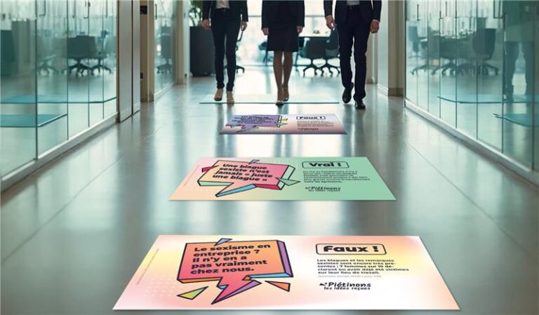 stickers au sol avec des phrases de lutte contre le sexisme dans un couloir d'une entreprise