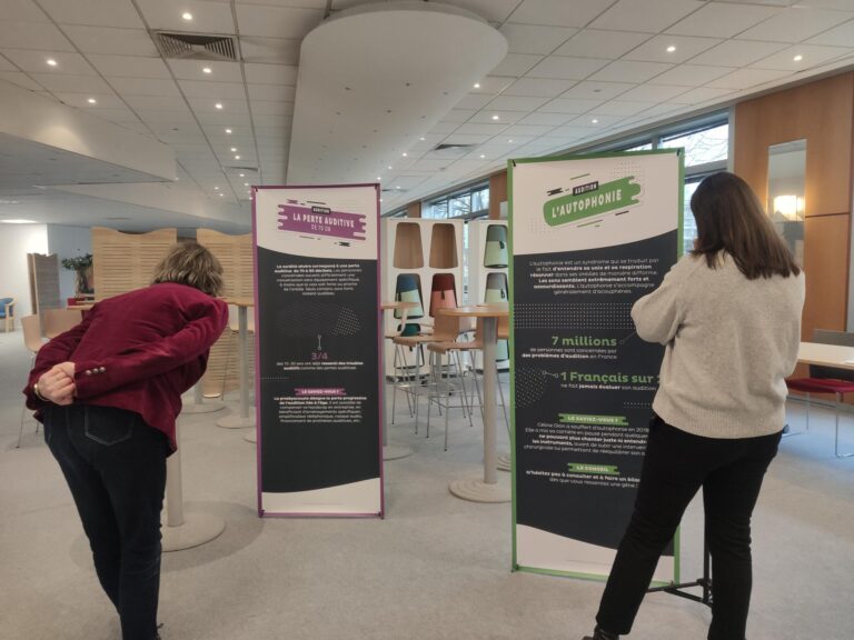 Photo de l'animation Ecoute moi, 2 personnes lisent les kakémonos perte auditive et autophonie